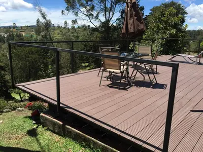 a wooden deck with a table and chairs on it at Espectacular Casa frente al campo de Golf in Rionegro