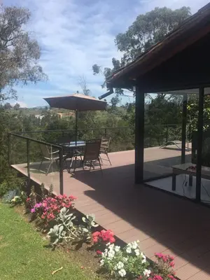 a patio with a table and umbrella and flowers at Espectacular Casa frente al campo de Golf in Rionegro