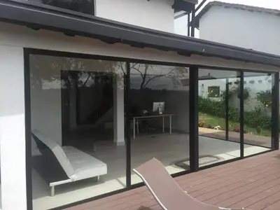 a patio with two chairs and a table at Espectacular Casa frente al campo de Golf in Rionegro