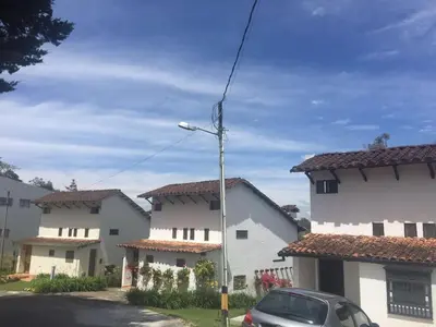 a car parked in front of two white houses at Espectacular Casa frente al campo de Golf in Rionegro