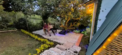 a couple of people sitting on top of a rock garden at Marinilla - Cabañas Perlas Black - in Marinilla