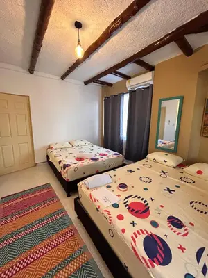 a bedroom with two beds and a rug at Jerusalén Hotel Boutique in Mariquita