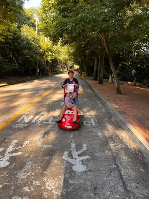 a man and a child riding on a toy car on a road at Jerusalén Hotel Boutique in Mariquita