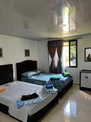 a bedroom with two beds and a window at Habitación la esmeralda in Puerto Triunfo