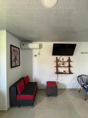 a living room with a couch and a tv at Habitación la esmeralda in Puerto Triunfo