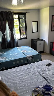 a bedroom with two beds and a window at Habitación la esmeralda in Puerto Triunfo