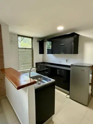a kitchen with a sink and a stainless steel refrigerator at Aparta hotel Montes in Medellín