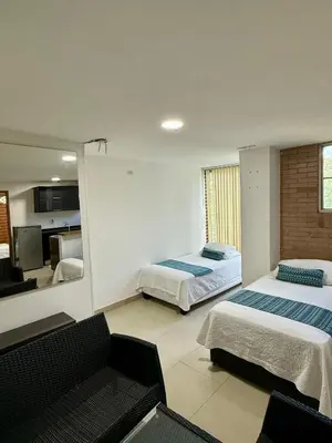 a hotel room with two beds and a mirror at Aparta hotel Montes in Medellín