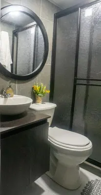 a bathroom with a toilet and a sink and a mirror at Apartamento en Rionegro in Rionegro