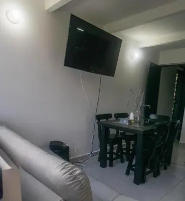 a living room with a table and a television on the wall at Apartamento en Rionegro in Rionegro