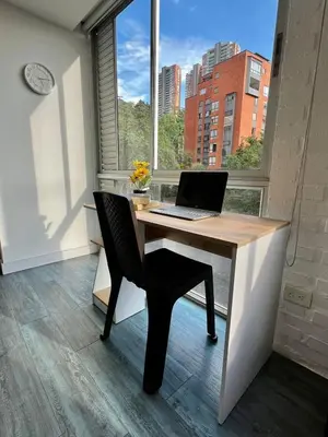 a laptop computer sitting on a desk in front of a window at Apartaestudio en el poblado cerca a Povenza 241 in Medellín