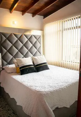 a bedroom with a large bed and a large window at Hermoso Apartamento Poblado - Manila in Medellín