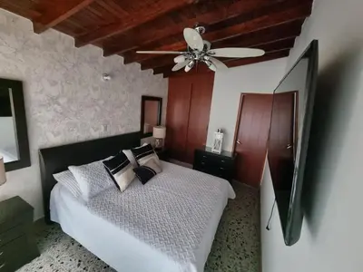a bedroom with a bed with a ceiling fan at Hermoso Apartamento Poblado - Manila in Medellín