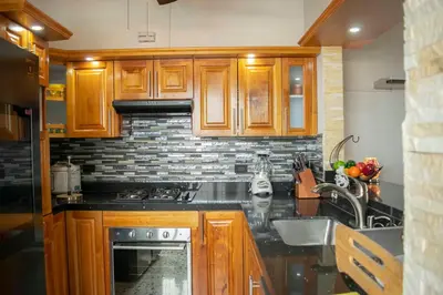 a kitchen with wooden cabinets and a sink at Hermoso Apartamento Poblado - Manila in Medellín