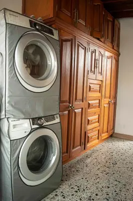 a washer and dryer in a kitchen with wooden cabinets at Hermoso Apartamento Poblado - Manila in Medellín