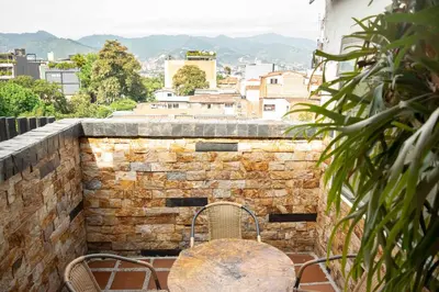 a stone wall with a table and chairs on a balcony at Hermoso Apartamento Poblado - Manila in Medellín