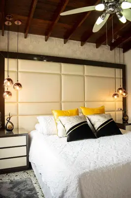 a bedroom with a large white bed with yellow pillows at Hermoso Apartamento Poblado - Manila in Medellín