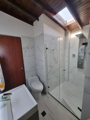 a bathroom with a toilet and a glass shower at Hermoso Apartamento Poblado - Manila in Medellín