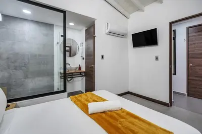 a bedroom with a large bed and a tv at MAKONDO - Large Jacuzzi and AC on Main Provenza St in Medellín