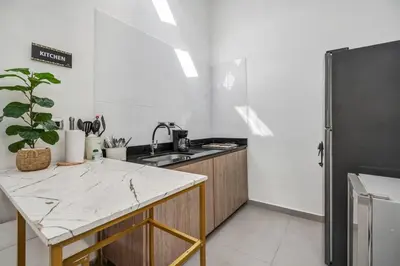 a kitchen with a counter top and a refrigerator at MAKONDO - Large Jacuzzi and AC on Main Provenza St in Medellín