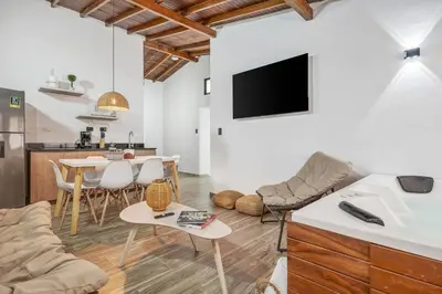 a living room with a couch and a table at CUMBIANA - Apt with Hot Tub on Provenza's Main Street in Medellín
