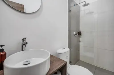 a bathroom with a sink and a toilet and a shower at CUMBIANA - Apt with Hot Tub on Provenza's Main Street in Medellín