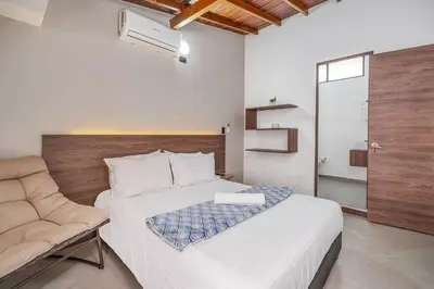 a bedroom with a large white bed and a couch at CUMBIANA - Apt with Hot Tub on Provenza's Main Street in Medellín