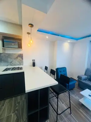 a kitchen and living room with a counter and chairs at Apto - Vista Única en Manizales in Manizales