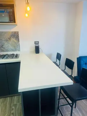 a white counter in a kitchen with two chairs at Apto - Vista Única en Manizales in Manizales