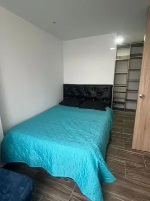 a bedroom with a bed with a blue comforter at Apto - Vista Única en Manizales in Manizales