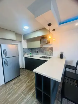 a kitchen with a white counter and a refrigerator at Apto - Vista Única en Manizales in Manizales