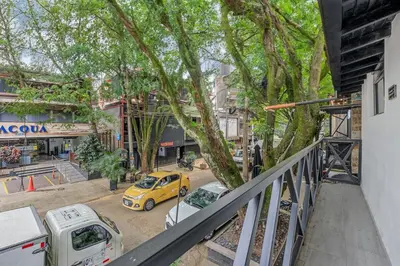 a yellow car parked next to a street with trees at GAIRA - Provenza Walkable Area, AC & Balcony facing KarolG club in Medellín