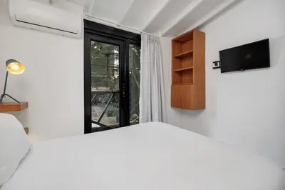 a bedroom with a white bed and a window at GAIRA - Provenza Walkable Area, AC & Balcony facing KarolG club in Medellín