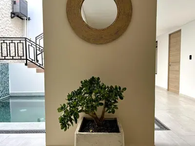 a round mirror on a wall with a potted plant at BALI - AC & Heated Pool in Provenza in Medellín