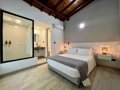 a bedroom with a bed and a large window at BORA BORA - Huge Jacuzzi, Rooftop & AC in Provenza in Medellín