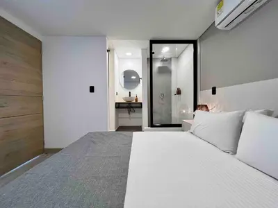 a bedroom with a large white bed in a room at BORA BORA - Huge Jacuzzi, Rooftop & AC in Provenza in Medellín
