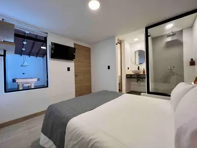 a bedroom with a bed and a window with a bathroom at BORA BORA - Huge Jacuzzi, Rooftop & AC in Provenza in Medellín
