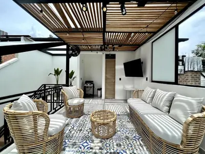 a living room with a couch and chairs on a balcony at BORA BORA - Huge Jacuzzi, Rooftop & AC in Provenza in Medellín