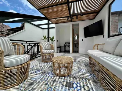a living room with a couch and wicker chairs at BORA BORA - Huge Jacuzzi, Rooftop & AC in Provenza in Medellín