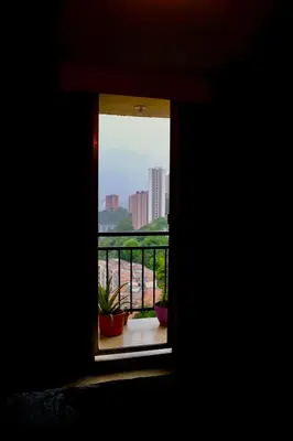 a room with a window with plants on a balcony at Coffee Retreat Peaceful Views and Local Soul in Medellín