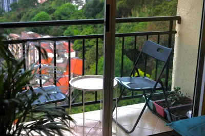 a balcony with two chairs and a table on a porch at Coffee Retreat Peaceful Views and Local Soul in Medellín