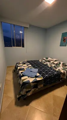 a bedroom with a bed in a room with a window at Coffee Retreat Peaceful Views and Local Soul in Medellín