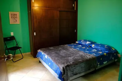 a bedroom with a bed and a green wall at Coffee Retreat Peaceful Views and Local Soul in Medellín