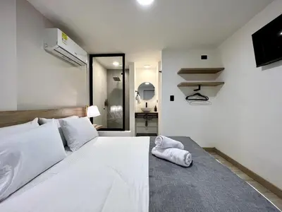 a bedroom with a white bed with a towel on it at FIJI - Jacuzzi & Outdoor Lounge in Provenza in Medellín