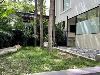 a house with palm trees in front of a building at FIJI - Jacuzzi & Outdoor Lounge in Provenza in Medellín