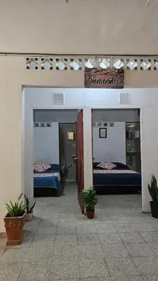 a room with two beds in a building with plants at Hospedaje Santa Teresita in Concepción