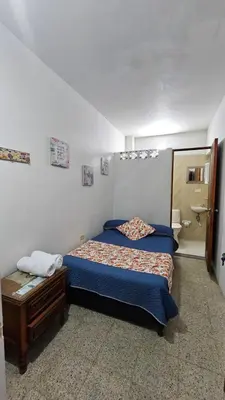 a bedroom with a bed and a sink and a toilet at Hospedaje Santa Teresita in Concepción