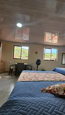 a bedroom with a bed and a table and windows at Hospedaje Santa Teresita in Concepción