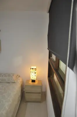 a bedroom with a bed and a table with a lamp at Apartamento entero cerca al Aeropuerto Internacional in Rionegro
