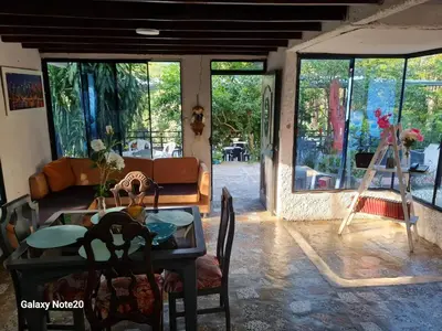 a living room with a table and chairs and windows at Beautiful duplex in Honda